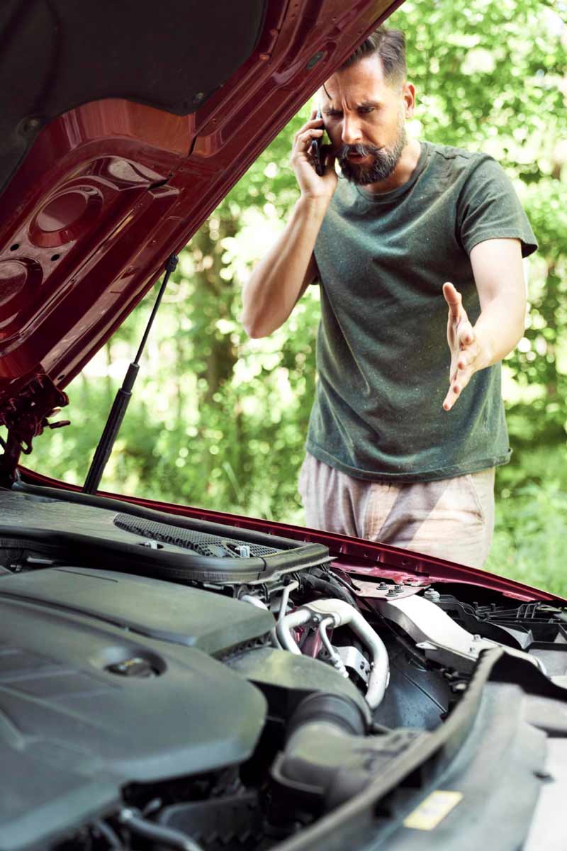 Junger Mann prüft Getriebeschaden bei Schrottauto Ankauf Plön